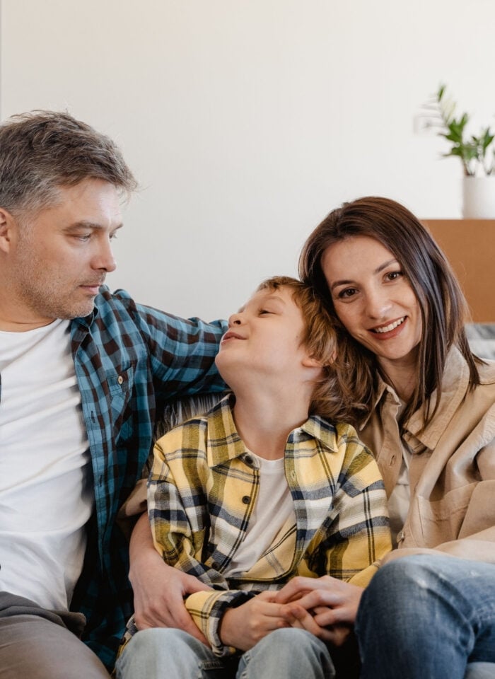 Family sitting together in their new home surrounded by moving boxes.
