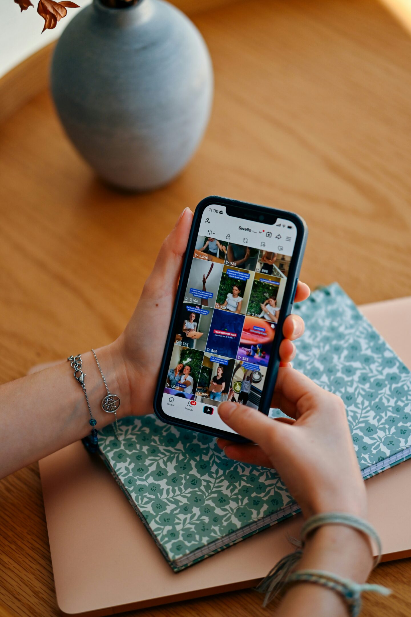 Hands holding a smartphone displaying a short-video social media app feed.