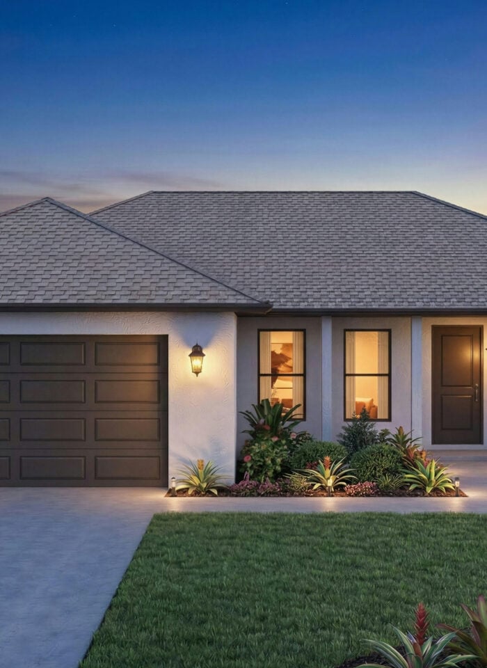 Single-story house at dusk with a double garage, illuminated front entrance, landscaped garden, and palm trees.